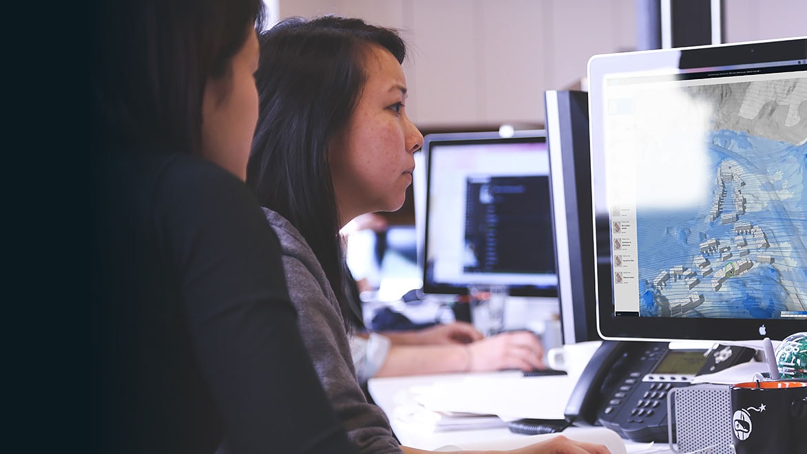 Two people work at a desktop computer running Spacemaker 